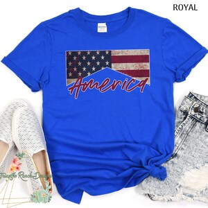 May include: A royal blue t-shirt with a distressed American flag design and the word "America" in red lettering.