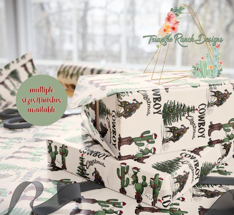 May include: A stack of three gift wrap sheets with a cowboy Christmas theme. The sheets feature a white background with green cacti, a Christmas tree, and a cowboy riding a horse. The text "Cowboy Christmas" is printed on the sheets.