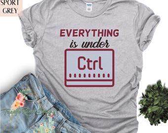 May include: A grey t-shirt with the text "Everything is under Ctrl" printed in red on the front. The text is stylized to look like a computer keyboard key.