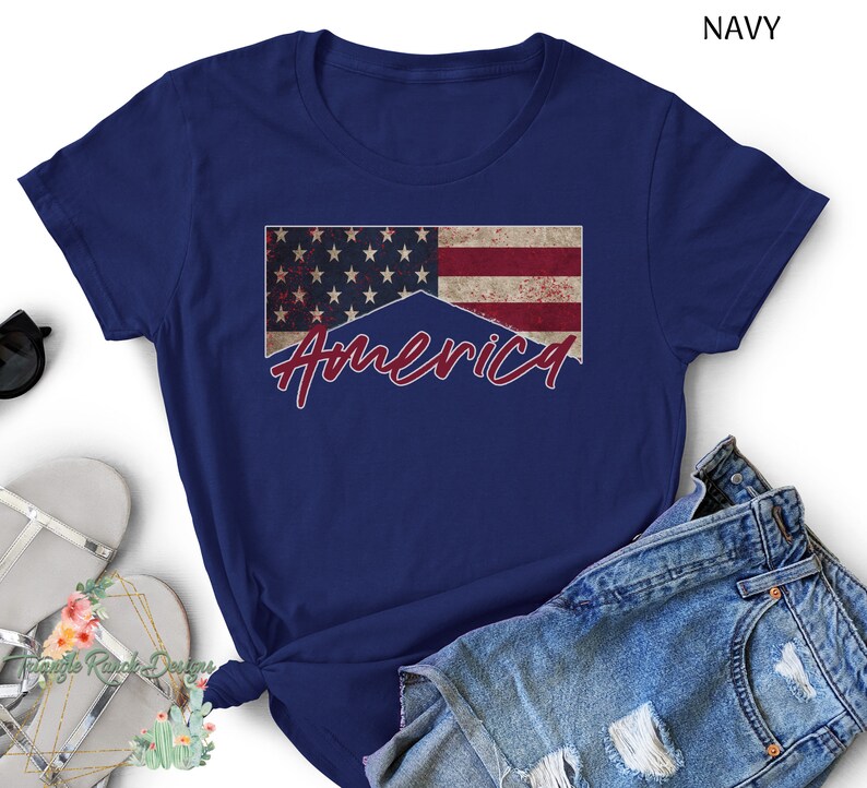 May include: A navy blue t-shirt with a distressed American flag and the word "America" in red script.
