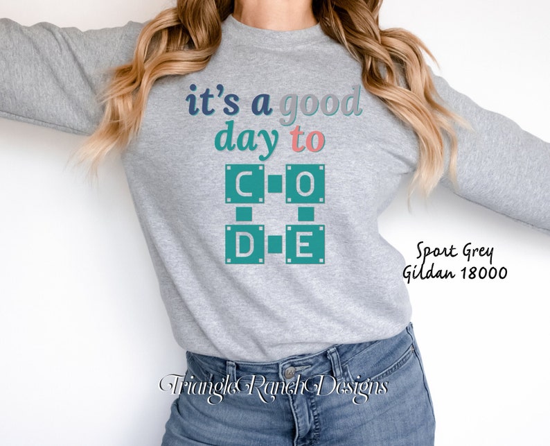 K&ouml;nnte beinhalten: Sportgraues Sweatshirt mit dem Text "it's a good day to CODE" in T&uuml;rkis, Blau und Rosa. Das Wort "CODE" ist in einem Blockbuchstaben-Design. Das Sweatshirt ist ein Gildan 18000. Die Marke "Triangle Ranch Designs" befindet sich unten.