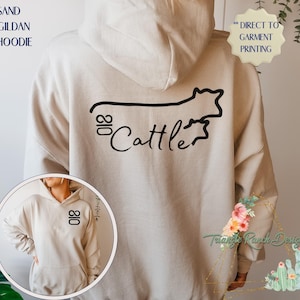 May include: Sand-colored hoodie with a black cow silhouette and the text "018 Cattle" printed on the back.