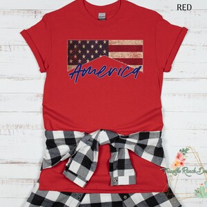 May include: Red t-shirt with a distressed American flag design and the word "America" in blue lettering.