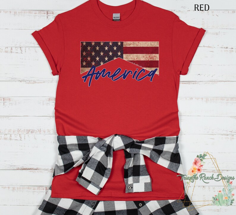 May include: Red t-shirt with a distressed American flag design and the word "America" in blue lettering.