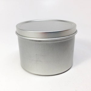 May include: A silver metal tin with a smooth, rounded lid. The tin is empty and ready to be filled.