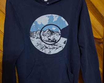 COLORADO Hooded Pullover Sweatshirt - "C" Logo With Mountains - All Blues With White Snow & Clouds - Size Small 38"x25"