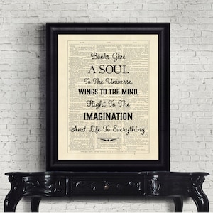May include: A framed print with a black frame, featuring text on a vintage book page. The text reads: "Books Give A SOUL To The Universe, WINGS TO THE MIND, Flight To The IMAGINATION And Life To Everything."