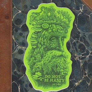 May include: Green sticker with a whimsical illustration of a tree-like figure with a beard and a crown of leaves. The sticker has the text "Do not be hasty" and "J.R.R. Tolkien" at the bottom.