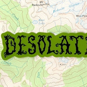 Op de afbeelding: Een groene en zwarte sticker met het woord "DESOLATION" in een gestileerd lettertype. De sticker heeft een golvende, organische vorm.