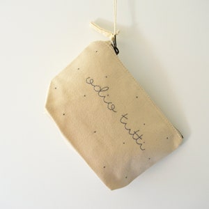 Handgeborduurde clutch van 100% biologisch katoen met de tekst "Ik haat iedereen".
