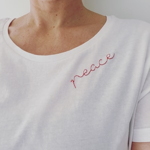 Handgeborduurd T-shirt van 100% biologisch katoen met de tekst "Peace".
