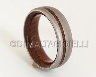 May include: A silver ring with a brown wood inlay. The ring has a polished finish and a thin silver band around the wood.