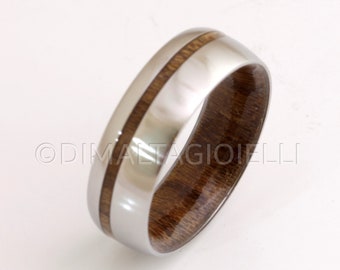 May include: A silver ring with a brown wood inlay. The ring has a polished finish and a smooth surface.