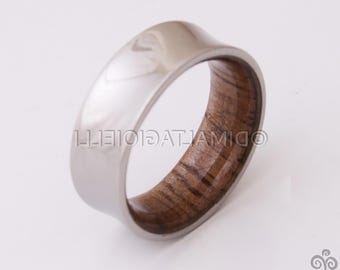 May include: A silver ring with a wooden inlay. The wood has a dark brown colour and a natural grain pattern.