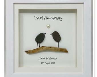 May include: A white framed picture with a pearl anniversary theme. Two small birds made of pebbles are perched on a piece of driftwood. A pearl heart is above the birds. The text reads "Pearl Anniversary" and "Jason & Vanessa 29th August 2021".