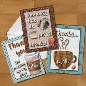 以下が含まれることがあります： コーヒーをテーマにした3枚のグリーティングカード。茶色と青色の背景で、コーヒーカップ、コーヒー豆、そして「優しさにはメリットがあります。ありがとう！」「ありがとう...ラテ！」「一日を明るくしてくれてありがとう！」というテキストが書かれています。