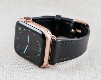 May include: A rose gold Apple Watch with a black leather strap. The watch face shows the time and the weather, which is 51 degrees and cloudy.