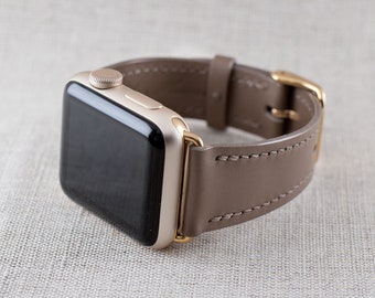 May include: A gold Apple Watch with a brown leather strap. The watch face is black and the strap has a gold buckle.
