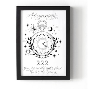 May include: Black framed art print with a black and white illustration. The artwork features a pocket watch design with the word "Alignment" above it. The number "222" is below the watch, with the text "You are in the right place. Trust the timing."