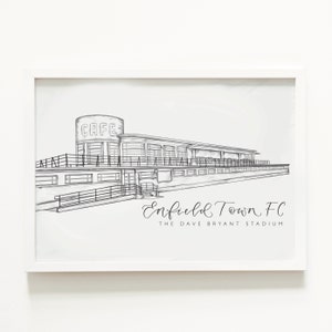 May include: Black and white line drawing of a stadium with the text "Enfield Town FC The Dave Bryant Stadium".