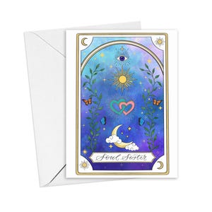 May include: A rectangular greeting card with a white envelope featuring a celestial illustration on a blue and purple gradient background. The design includes a central sun, an eye, two interlocking hearts, a crescent moon, vines, and butterflies.
