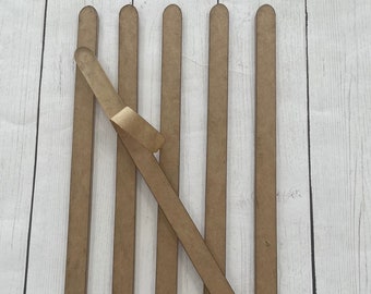 May include: Six brown wooden dowels with rounded ends. One dowel is lying diagonally across the others.
