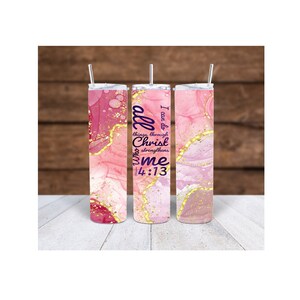 May include: Three stainless steel insulated tumblers with pink, gold, and white marble-like designs. Each tumbler has a straw and features the text "I can do all things through Christ who strengthens me 14:13" in purple.