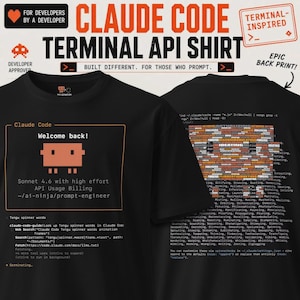 May include: A black t-shirt featuring a terminal-style interface on the front with an orange pixelated character, the text Welcome back!, and code snippets. The back displays a large block of text composed of various words in orange and white.