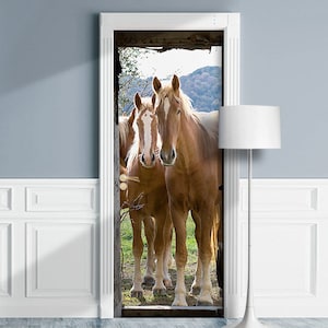 May include: Three brown horses stand in a field, looking towards the camera. The horses are in a grassy field with trees in the background.