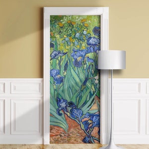 May include: A door decorated with a painting of irises in a field. The artwork features blue, green, and yellow flowers with long green leaves. The door is framed in white and set against a yellow wall.