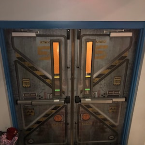 May include: A pair of industrial-style double doors with a weathered metal finish. The doors feature yellow and black hazard stripes, caution labels, and an illuminated "EXIT" sign above. The door frames are trimmed in blue.