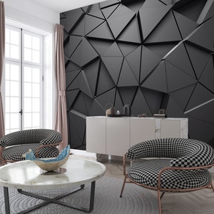 May include: A living room interior with a black and white geometric wallpaper, two black and white patterned armchairs, a white coffee table with a blue and white decorative bowl, and a white cabinet with a marble top.