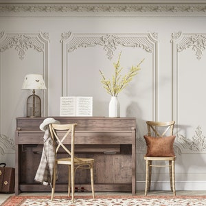May include: A vintage-style piano with a wooden top and a white lamp with a birdcage shade. Two chairs with brown cushions are placed in front of the piano. The room has white walls with ornate molding and a rug with a floral pattern.