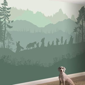 Può includere: Un murale raffigurante una scena silhouette di un gruppo di figure, un cavallo e una catena montuosa in tonalità di verde. Un cane è seduto di fronte al murale su un pavimento di legno. Il murale evoca un tema fantasy o avventura.