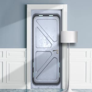 Op de afbeelding: Een metallic grijze deur met een geklonken ontwerp, geplaatst in een wit deurkozijn. De deur heeft een handvat en een klein raam. Een witte vloerlamp staat rechts van de deur, tegen een lichtblauwe muur.