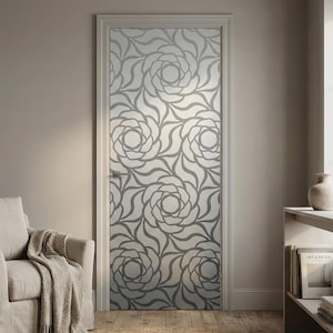 May include: A decorative interior door with a floral pattern. The design features large, stylized gray roses against a frosted glass background. The door is set in a white frame and is a focal point in a neutral-toned room.