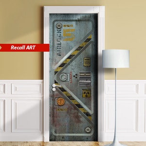 May include: A door decal featuring a weathered metal airlock design with yellow and black hazard stripes. The door has various warning labels and the text "AIRLOCK" and "CAUTION". The decal is framed in white and has the text "Recall ART" in a red banner.