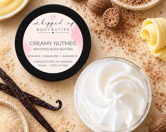 May include: A round black container of Creamy Nutmeg whipped body butter with a label featuring a pink watercolor accent, text, and ingredients list. Beside it sits an open clear jar filled with white whipped body butter in a swirl pattern.