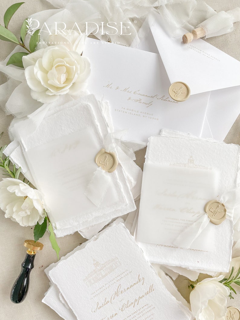May include: A stack of white wedding invitations with gold lettering and wax seals. The invitations are on textured paper and have a delicate, elegant design. The text on the invitations reads "The honor of your presence is requested at the marriage of Sasha Hernandez and Lauren Chapparelli".