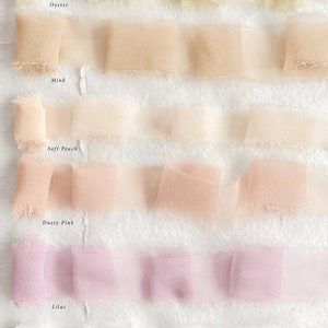 May include: Six samples of sheer ribbon in various shades of white, peach, pink, and lilac. The ribbon samples are labeled "Oyster", "Mink", "Soft Peach", "Dusty Pink", "Lilac", and "White".