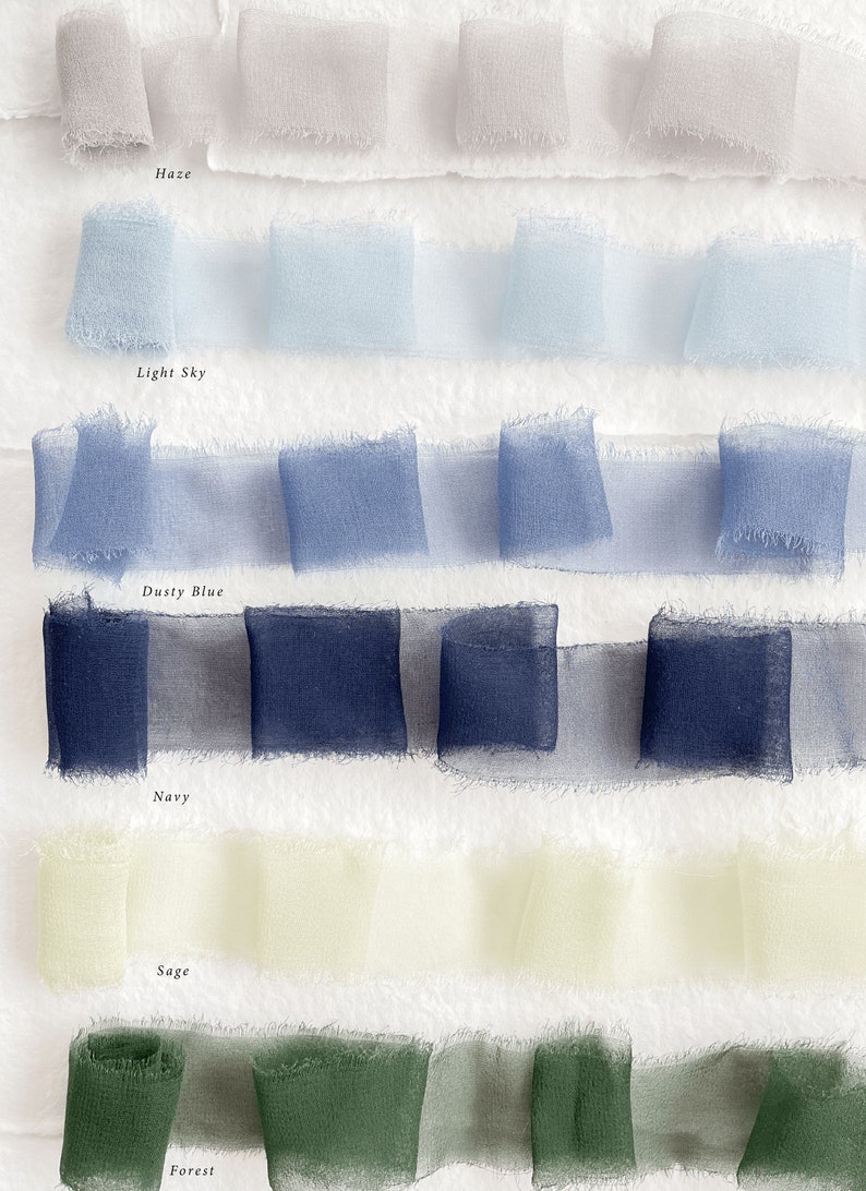 May include: Six rows of sheer ribbon in various shades of blue, green, and beige. The ribbon is arranged in rows with the names "Haze", "Light Sky", "Dusty Blue", "Navy", "Sage", and "Forest" written below each row.