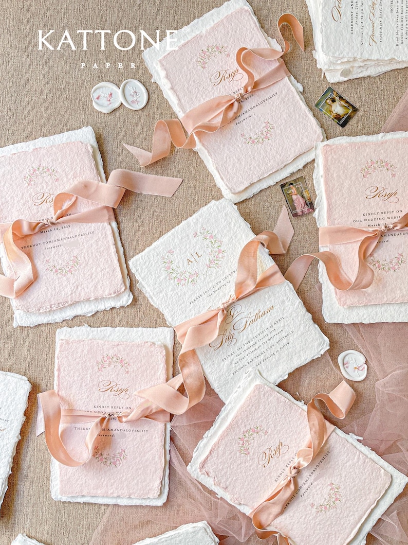 This exquisite handmade paper wedding invitations suite offers a blend of classic elegance and personalized artistry. Each bespoke invites set features a custom, hand-painted watercolor monogram of your initials, creating a unique and personal touch. The invitations are beautifully assembled with luxurious satin silk ribbons, adding a soft, opulent texture that your guests will adore.
