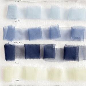 May include: Six rows of sheer ribbon in various shades of blue, green, and beige. The ribbon is arranged in rows, with each row containing three pieces of ribbon. The ribbon is labelled with the following colours: Haze, Light Sky, Dusty Blue, Navy, Sage, and Forest.