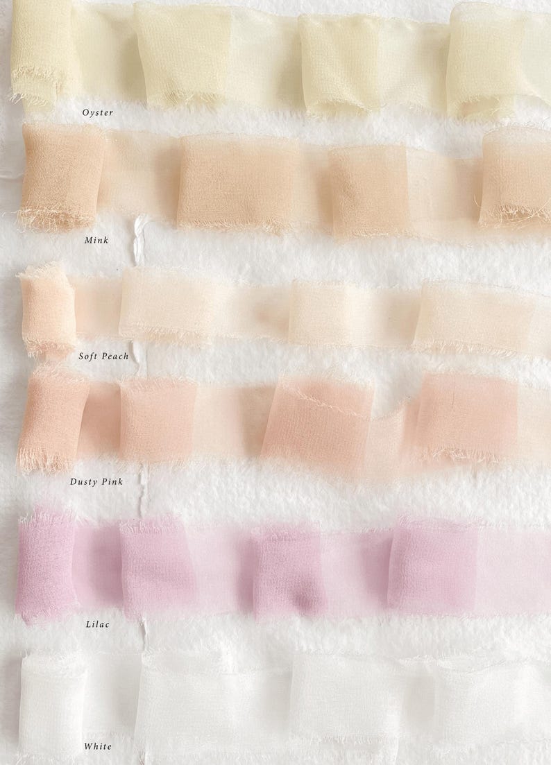 May include: Close-up of several rows of ruffled fabric ribbon in pastel shades: oyster, mink, soft peach, dusty pink, lilac, and white. The fabric has a delicate, sheer appearance with frayed edges.