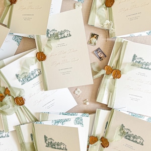 May include: A collection of wedding invitation cards featuring a beige cardstock with a green ink illustration of a villa, sage green silk ribbon, and a gold wax seal. The text reads Welcome to the wedding of and includes date and location details.