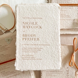Handmade cotton paper wedding invitation with organic deckle edges featuring warm terracotta typography printed on textured ivory handmade paper for luxury fine art wedding stationery.