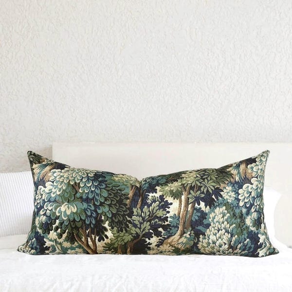 Pode incluir: Uma almofada retangular longa com um padrão floral verde escuro, azul e branco. A almofada apresenta um desenho repetitivo de árvores e folhas estilizadas.