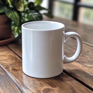 May include: A white ceramic mug with a rounded handle. The mug is sitting on a wooden table.