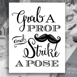 May include: Black and white printable sign with the text "Grab a Prop and Strike a Pose". The text is in a decorative font with a black mustache graphic.