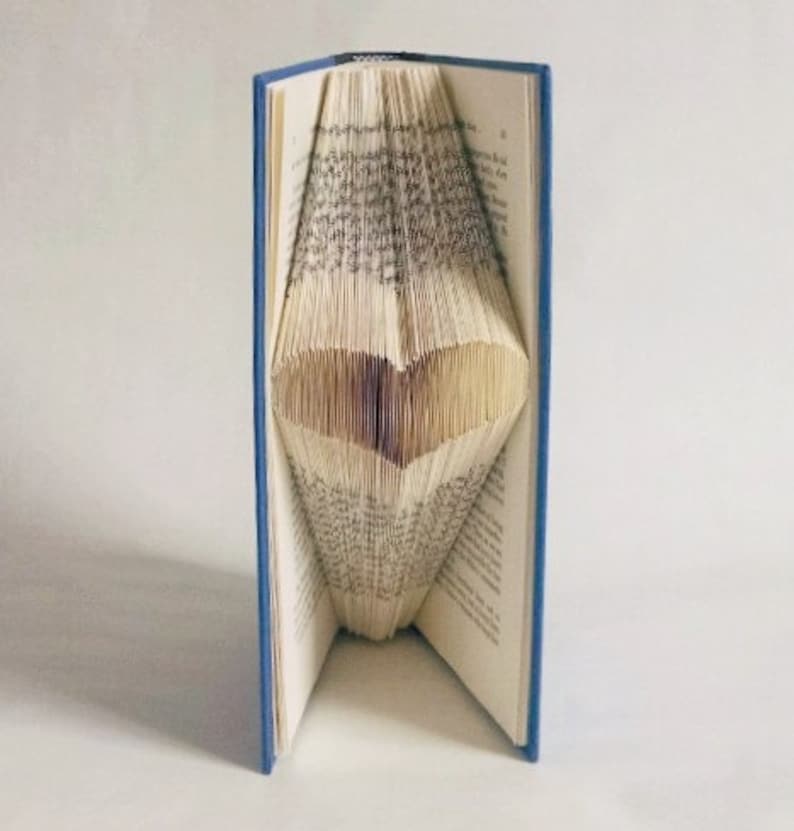 May include: A blue hardback book with the pages folded into a heart shape.